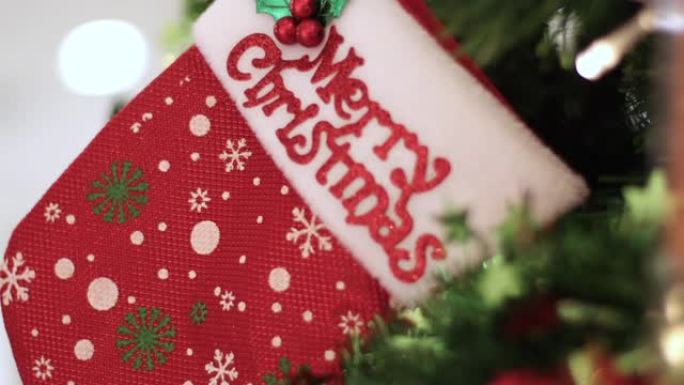 4k特写圣诞袜子挂在圣诞树上，圣诞快乐新年快乐，家庭室内装饰，明亮的灯光，礼物玩具，圣诞老人，驯鹿，