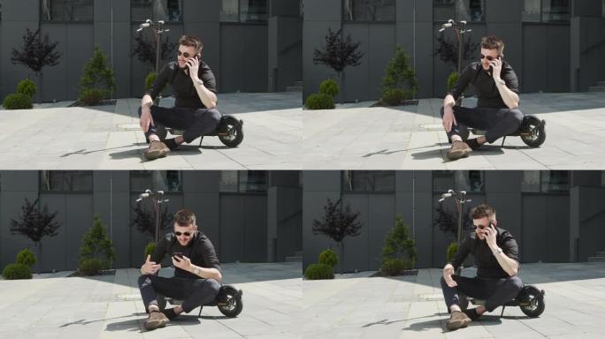 一名男学生坐在街道中央的电动滑板车上，用手机交流，表现出负面情绪。戴着黑色眼镜的白人男子骑着电动滑板