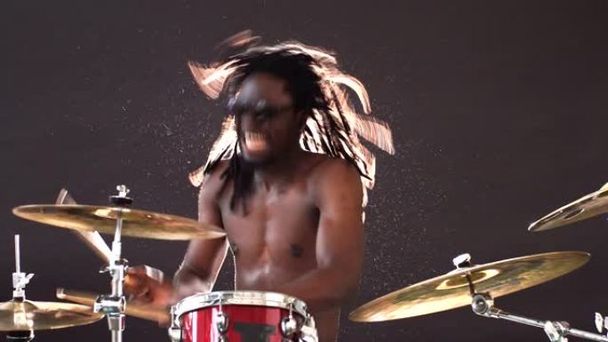 充满活力的非洲鼓手在情感上演奏打击乐器