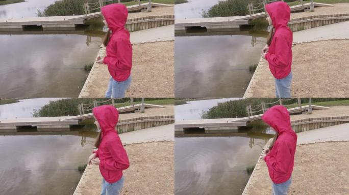 小女孩在玩，往水里扔石头
