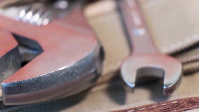 locksmith的工具可调节扳手在旋转桌上的帆布袋口袋中的特写镜头。浅景深。