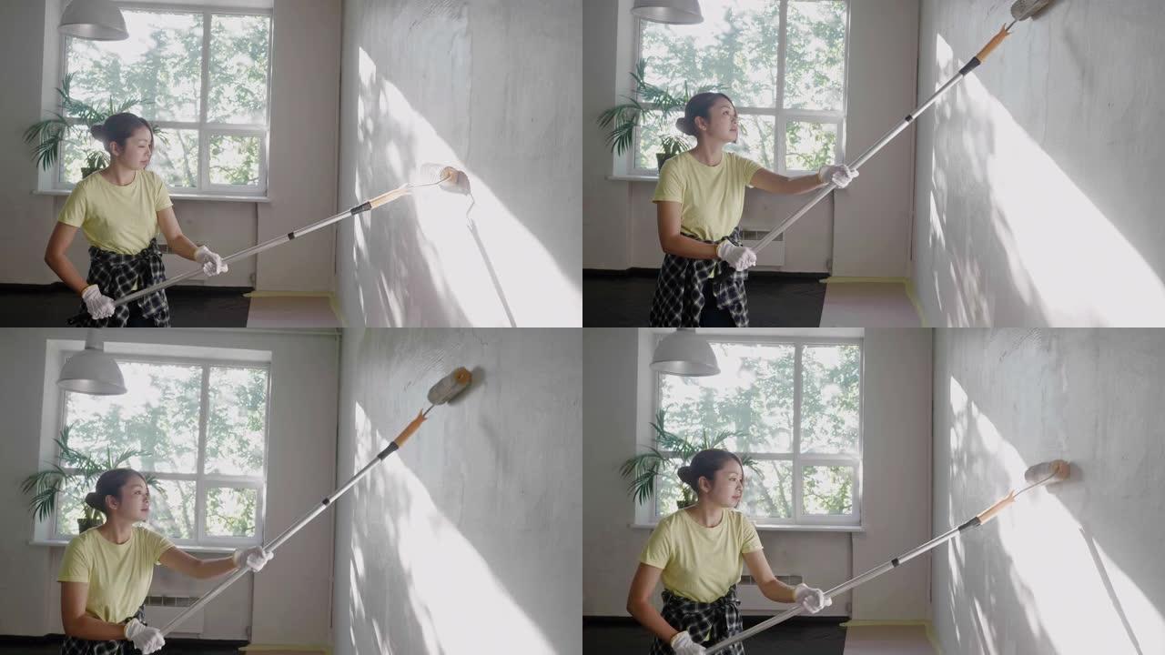 日本妇女在家用油漆滚筒粉刷墙壁