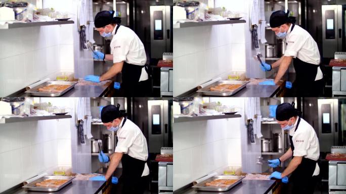 烹饪。一位男厨师，戴着防护手套和面具，正在用鸡排做排骨。为顾客准备食物。健康食品。志愿服务和慈善机构