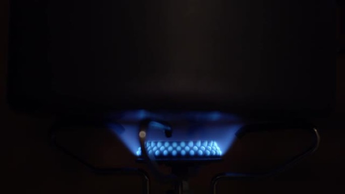 在气体喷射黑暗背景中燃烧蓝色火焰的特写视频镜头