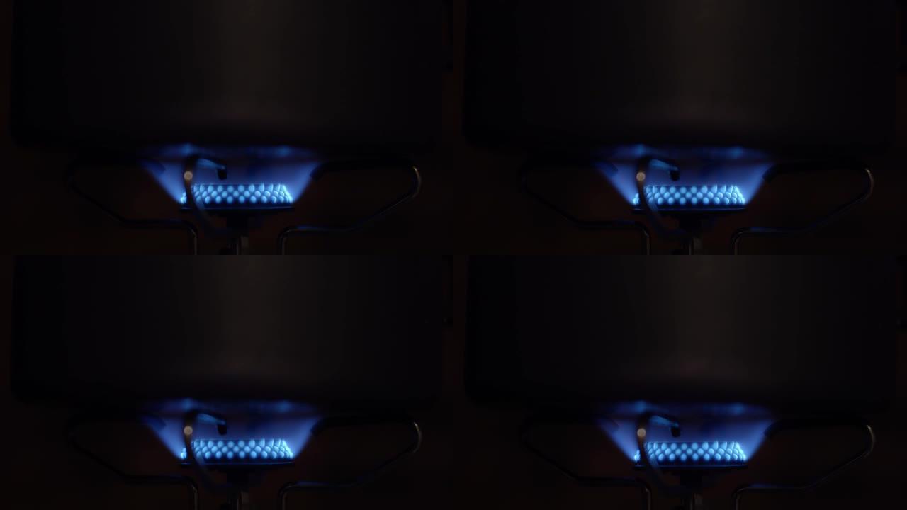 在气体喷射黑暗背景中燃烧蓝色火焰的特写视频镜头
