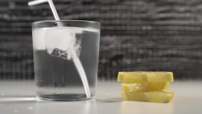 黑色和白色背景上的蒸玻璃杯中的一管水和冰。