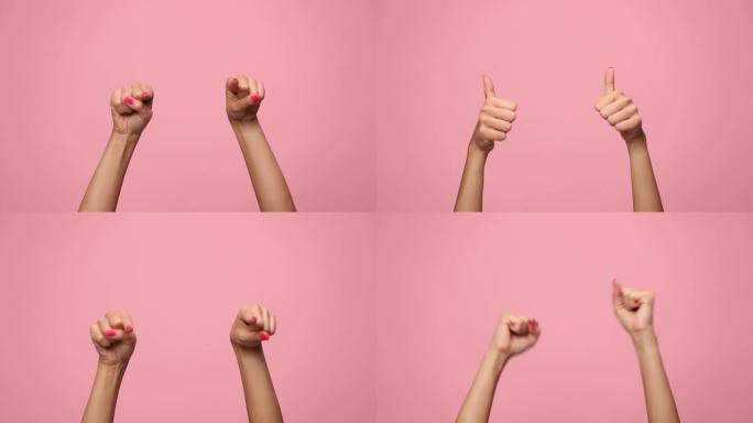 女人的手指着手指，竖起大拇指手势并在粉红色背景上庆祝胜利