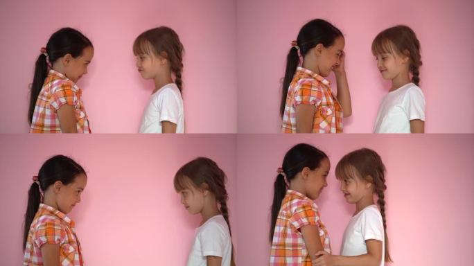 两个小女孩在粉红色的背景上生气并大笑