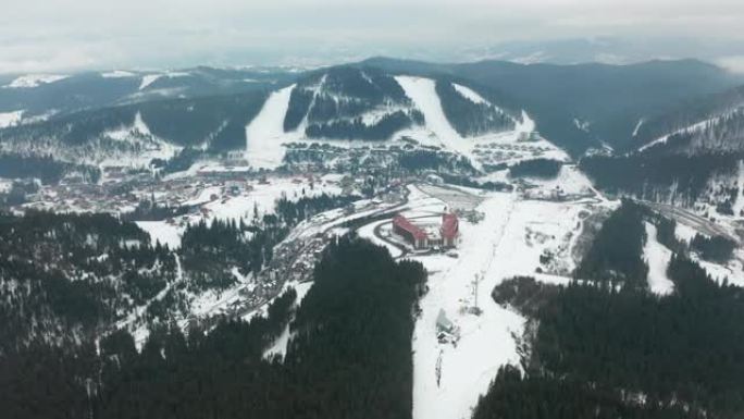 在雪山的冬季森林中，滑雪场上有滑雪者和滑雪缆车的滑雪场的鸟瞰图。晴天。有松树的滑雪道。喀尔巴阡山。布
