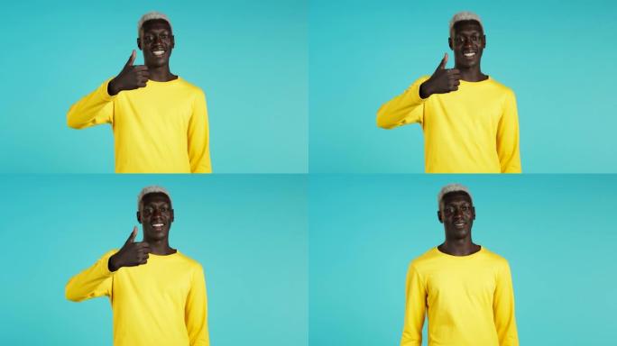 非裔美国人对镜头微笑。竖起大拇指的家伙，就像蓝色背景上的标志。赢家。成功。肢体语言。