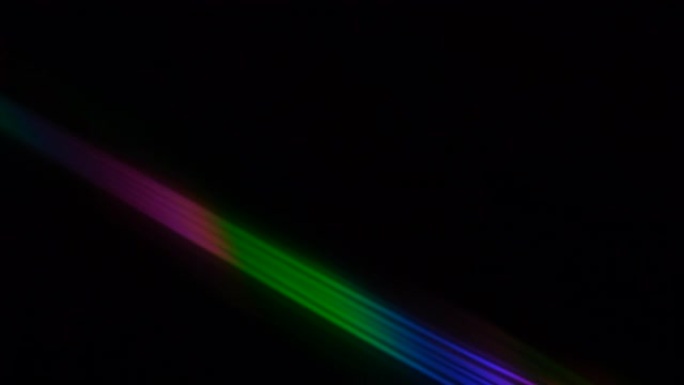 黑色背景上的彩色光束和光线。光盘上的抽象背景彩虹。美丽的彩色镜头灯光彩虹光束，用于晚上的电影和电影。
