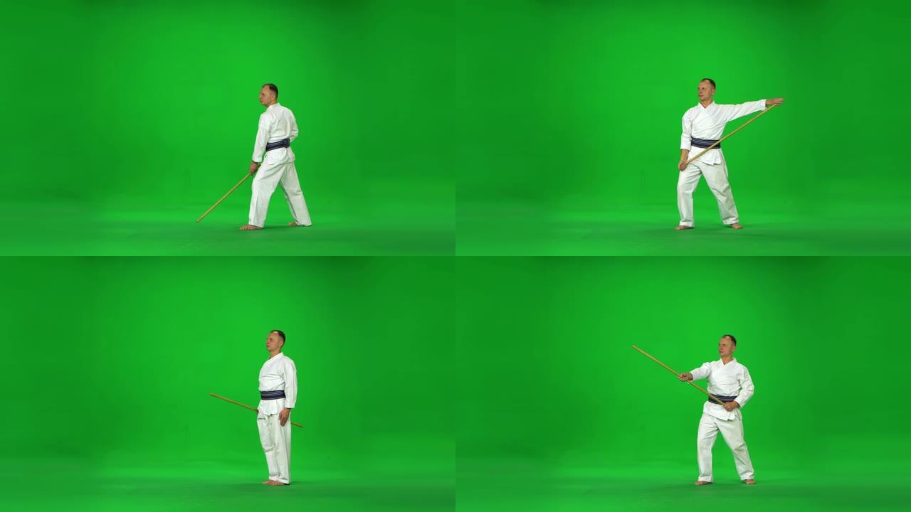 白色和服战士的男性剑道大师在绿色屏幕上与竹子博肯一起练习武术
