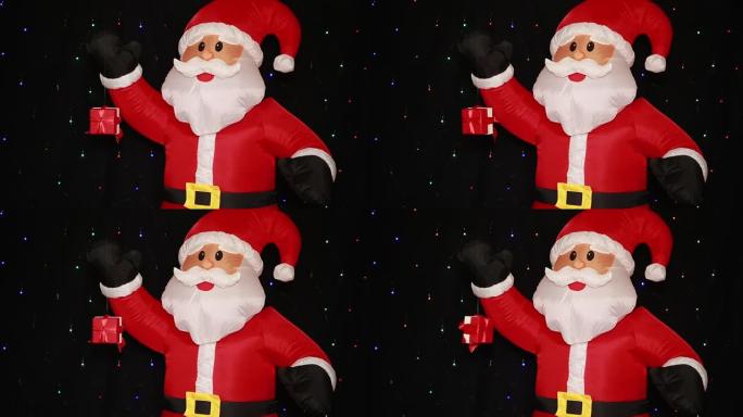大充气圣诞老人娃娃在圣诞帽红色西装外套黑色手套和礼物，礼品盒在空中旋转。