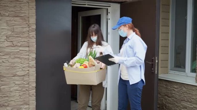 在检疫送餐，因大流行而隔离的年轻女孩收到一名戴着医用口罩、眼镜和手套的女快递员的食物订单