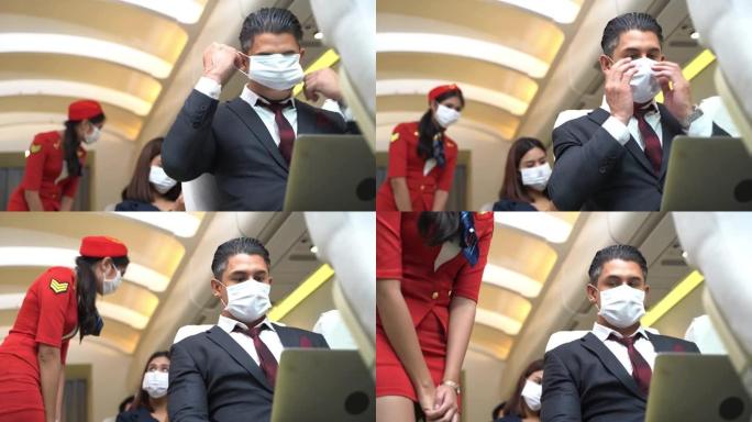 商人坐在窗户附近的飞机椅子上后戴着口罩。健康保障航空旅行运输的概念新常态。