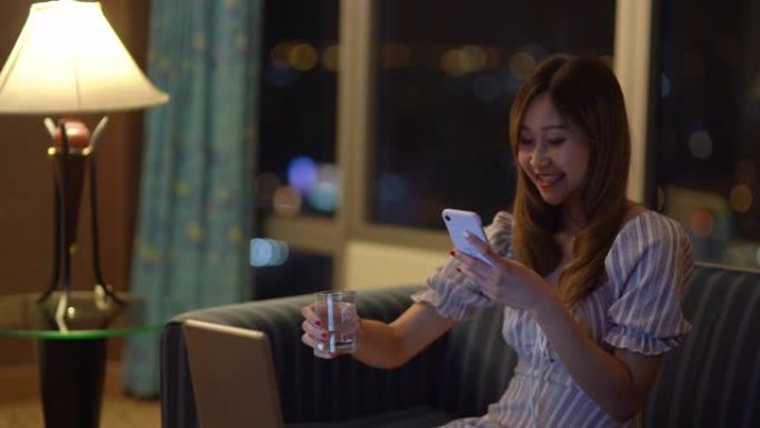 一个中国女孩在公寓里用笔记本电脑通过“网恋”手机应用进行视频通话