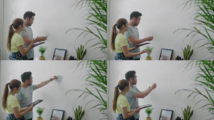 年轻夫妇在使用数字平板电脑时为墙壁选择合适的颜色