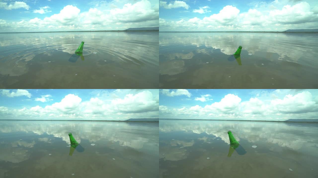 漂浮在河里的空绿色瓶子