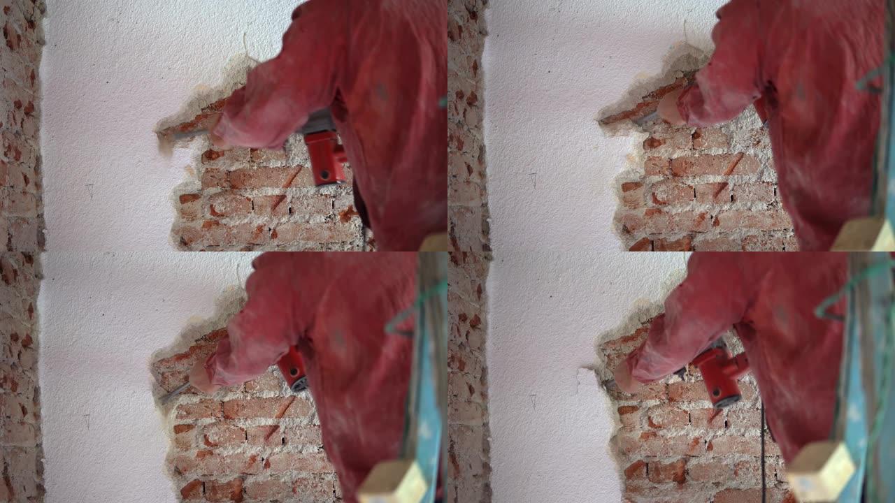 建筑工人用电锤拆除旧砖墙