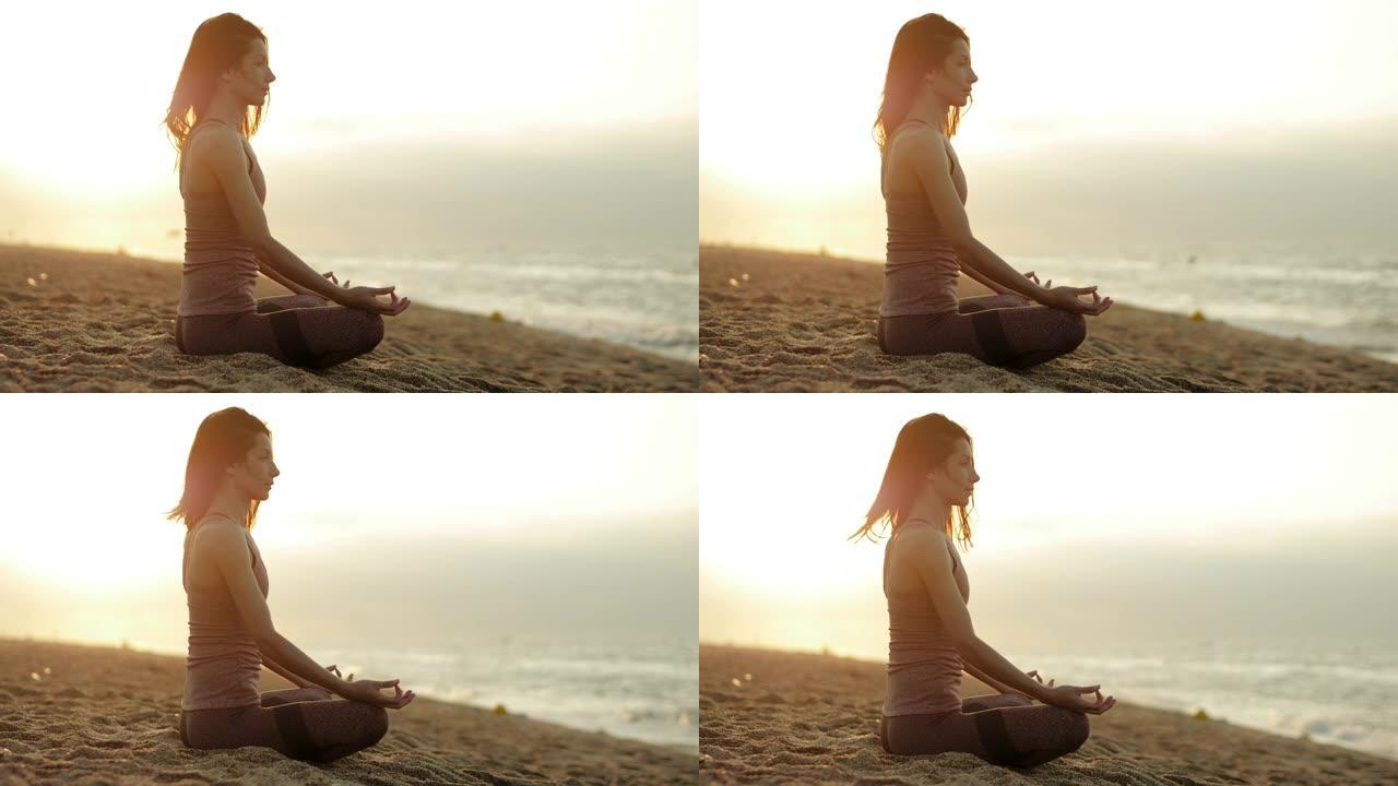 美丽的女人轻轻地呼吸的特写镜头，坐在莲花的姿势，在夏天的早晨在地中海边练习精神瑜伽。卡雷拉。巴塞罗那