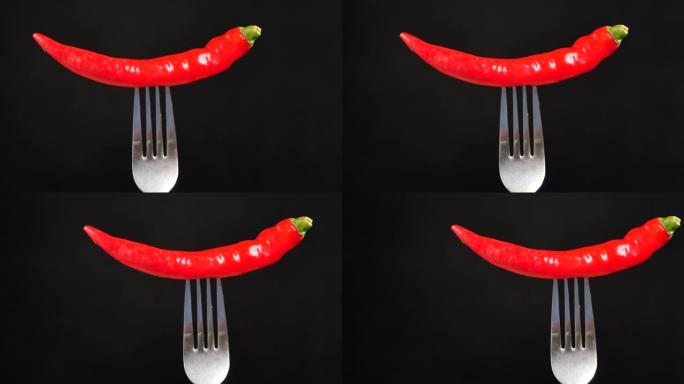 黑底叉子上的红辣椒。