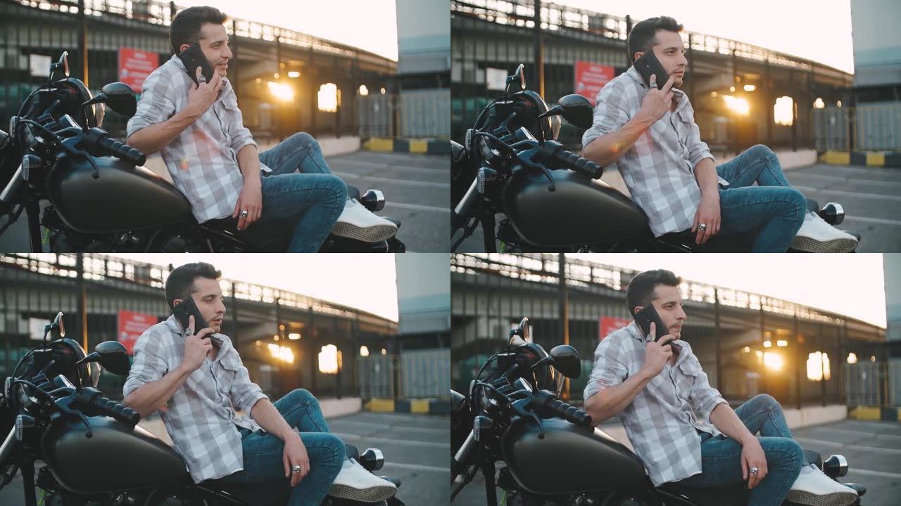 年轻的摩托车手坐在定制摩托车上打电话