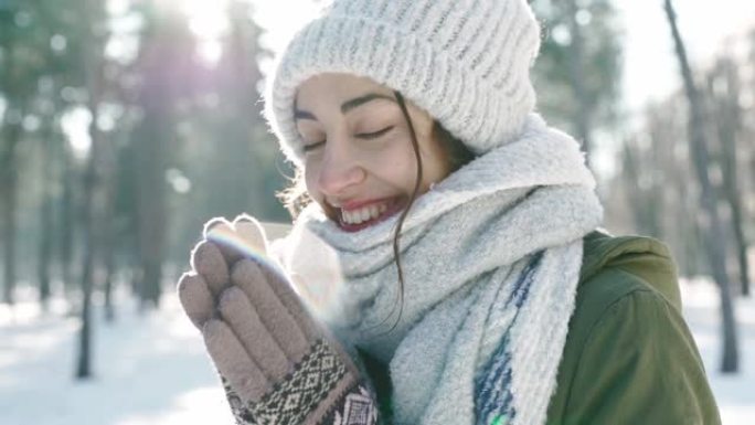 在寒冷的晴天，白雪皑皑的冬季公园里，穿着羊毛帽和长长的温暖围巾的美丽微笑女人的极端特写肖像。女人看起