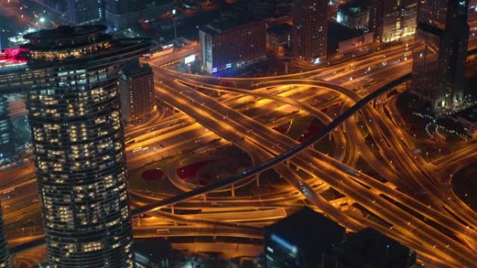 迪拜夜大城市，有摩天大楼和道路交叉口汽车交通，从上面看