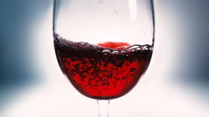 红酒倒入玻璃杯的创意宏观慢动作视频。玻璃杯与倒红酒特写。旧复古垃圾复古风格。