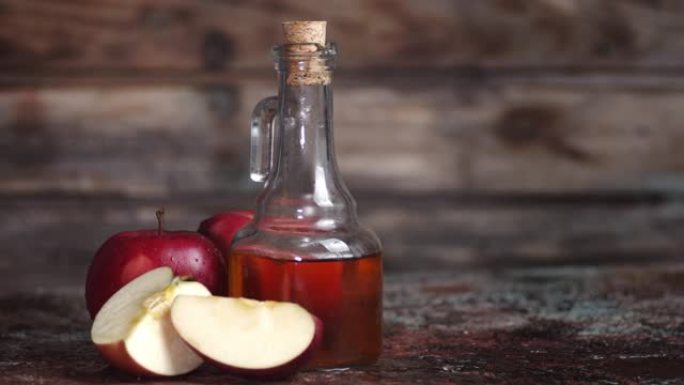 苹果醋在木桌上旋转。