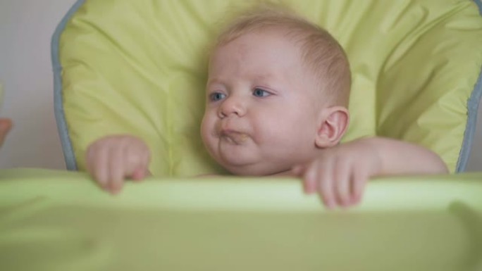 婴儿坐在高脚椅上吃饭，食欲大增