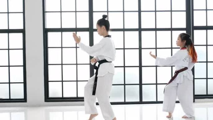 跆拳道的年轻老师和她的学生的基本姿势是白色背景和图案。关于腰带和学生的课文是指跆拳道。