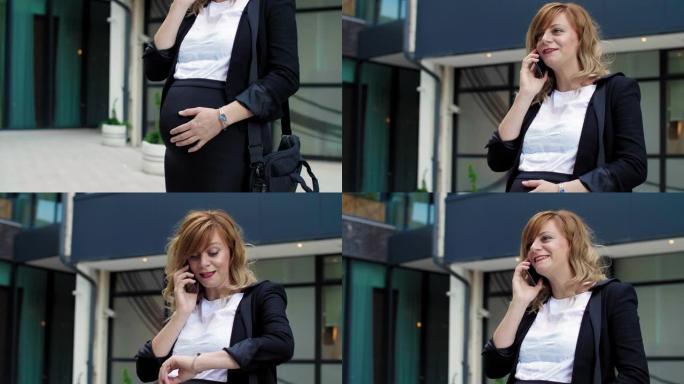 一个微笑的怀孕女商人站在街上用手机聊天