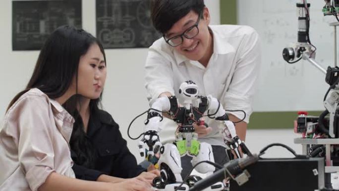 亚洲青少年工程师在实验室组装和测试机器人反应。建筑师设计电路会议共享技术思想和协作开发机器人。