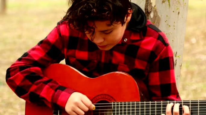 十几岁的男孩在森林里弹吉他
