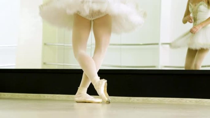 舞蹈工作室中，女芭蕾舞演员的脚脚尖着脚尖鞋跳舞