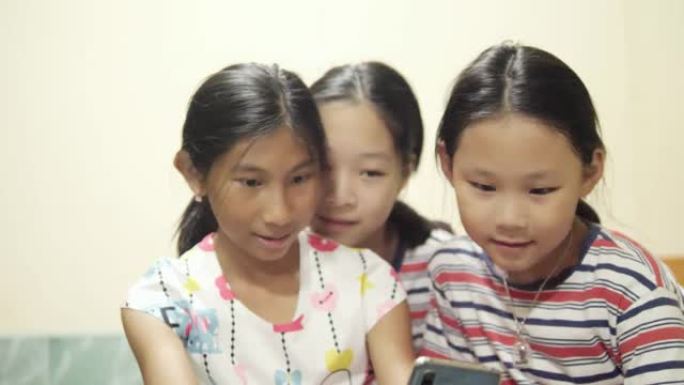 快乐的亚洲儿童在家里，生活方式和技术概念一起通过智能手机拍照。