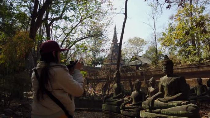 年轻女子在老庙和佛头雕像旅行