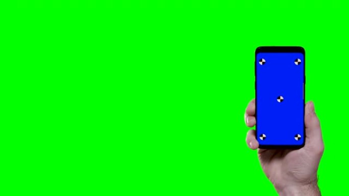 手持蓝色croma关键跟踪点和背景绿色屏幕的智能手机进入屏幕右侧