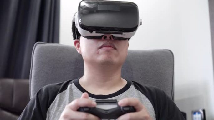 亚洲男子在家中沙发上使用虚拟现实耳机。