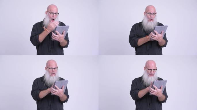 成熟的秃头大胡子男人使用数字平板电脑