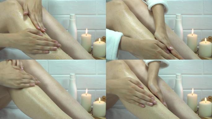 将磨砂膏涂在腿部皮肤上。家庭护肤，身体。脱毛后的刺激，剃须。水疗、治疗、按摩。去角质，脱皮。草莓腿，