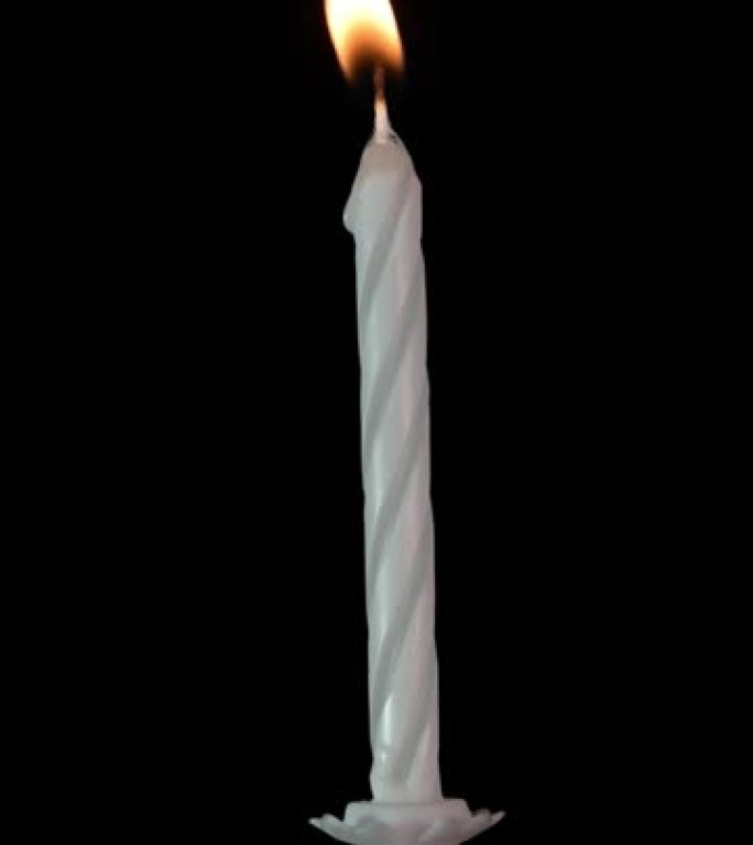 黑色背景上燃烧的银白色生日蜡烛。