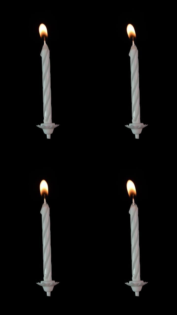 黑色背景上燃烧的银白色生日蜡烛。