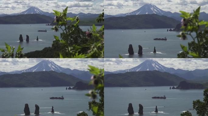 海港的海景，前面是绿色植物，中间是一艘船，悬崖在水中，远处是大火山。
