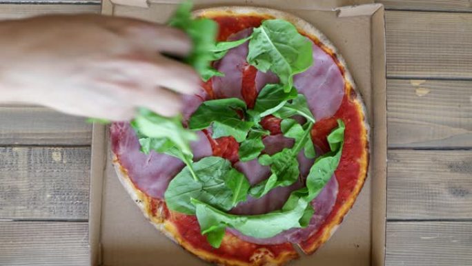 用绿色蔬菜在盒子里装饰整个披萨