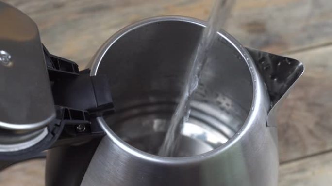 将水倒入金属电热水壶中。