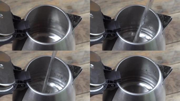 将水倒入金属电热水壶中。
