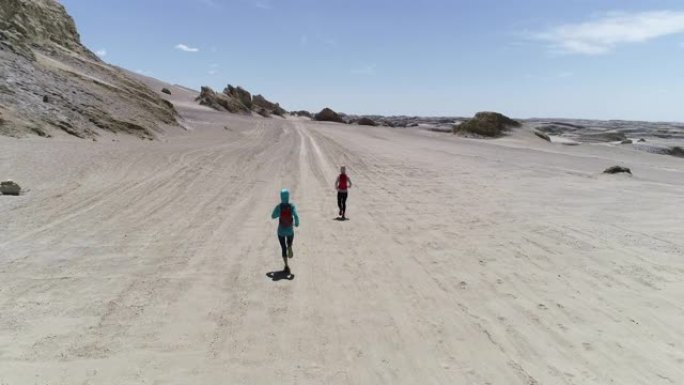 两名女子越野跑运动员在沙漠中越野跑