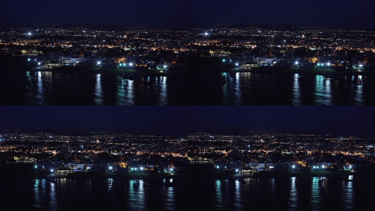 帕福斯堤防或长廊在夜间的鸟瞰图，并在海水中反射城市灯。著名的塞浦路斯地中海度假胜地